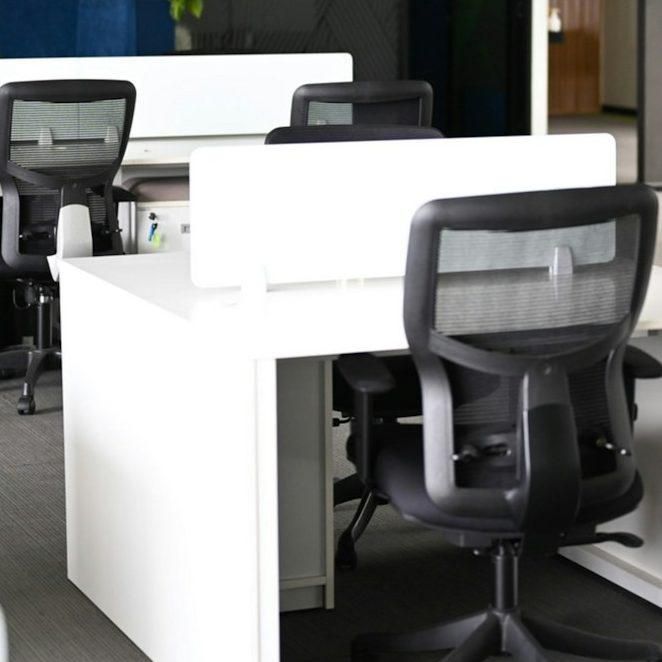 Office movers moving a sofa in plastic for protection during an office relocation.